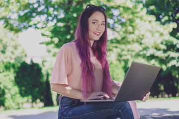 Young girl is studying in the spring park, sitting on the wooden