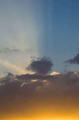 Landscape with dramatic light - beautiful golden sunset with saturated sky and clouds.