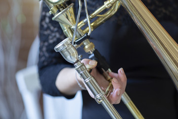 Fototapeta premium Hands of a girl playing the trombone