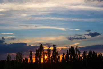 Naklejka premium Landscape with dramatic light - beautiful golden sunset with saturated sky and clouds.