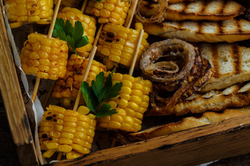 Close view of grilled corn and onion rings