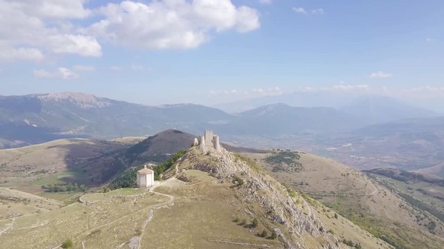 AERIAL: drone flying over the mountains towards the castle of Rocca Calascio, Abruzzo, Italy, in a sunny day.