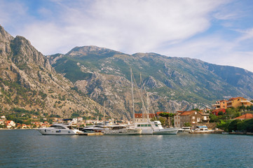 Fototapeta premium Mediterranean landscape with yachts moored at the pier. Montenegro, Adriatic Sea, Bay of Kotor, Muo village