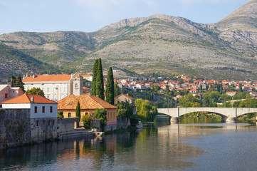 Fototapeta na wymiar Ancient town on river bank. Bosnia and Herzegovina, Republika Srpska. View of Trebisnjica river and Old Town of Trebinje, autumn