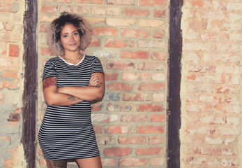 Punkgirl steht an Backsteinmauer