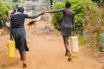 women carrying water cans in Uagnda, Africa