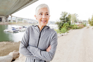 Smiling Senior Woman With Earphones Listening Music Workout