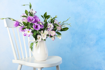 Vase with bouquet of beautiful flowers on chair against color background. Space for text