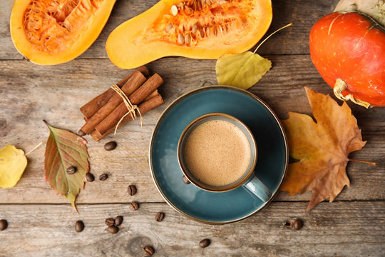 Flat lay composition with pumpkin spice latte in cup on wooden background