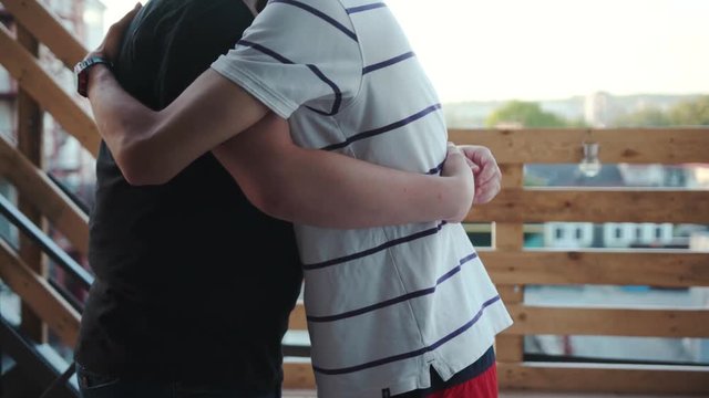 Two young man gay couple hug have funny in balcon sunlight touches the ass homosexual men caucasian love male people relationship tenderness together handsome adults marriage sex slow motion