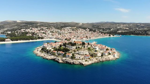 A drone shot of Primosten, Croatia. You can see the town and the sea around it.
