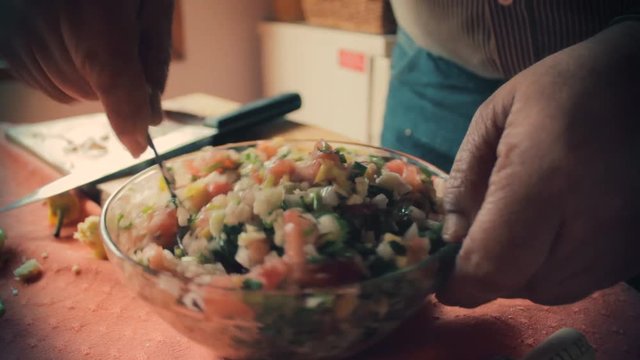 Chef mixing all the vegetables with a spoon in a bowl