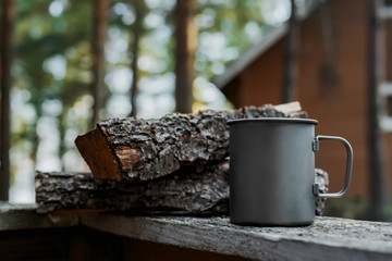 Metal mug in the nature next to the wood