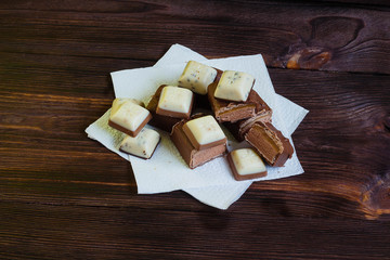 dark and white chocolate on white napkin, wooden background