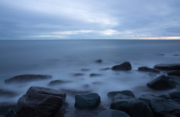 Fototapeta na wymiar Long exposure of pacific ocean water on rocks
