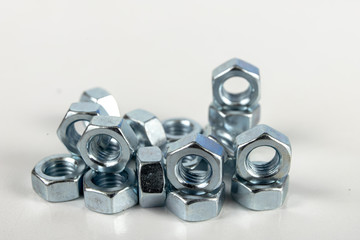 Chrome caps on a white table. Accessories for mounting steel structures on a workshop table.