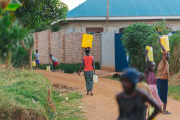 woman carrying water can in Uganda, Africa