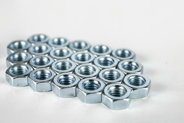 Chrome caps on a white table. Accessories for mounting steel structures on a workshop table.