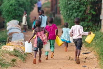 Fototapeten Kinder tragen Wasserkanister in Uganda, Afrika © Dennis