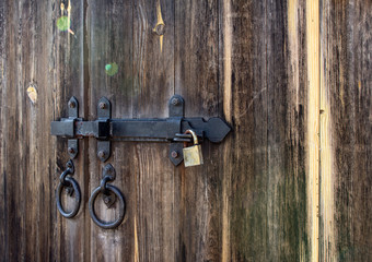 texture of an old wooden gate with a large lock. An old wooden gates in the park.
