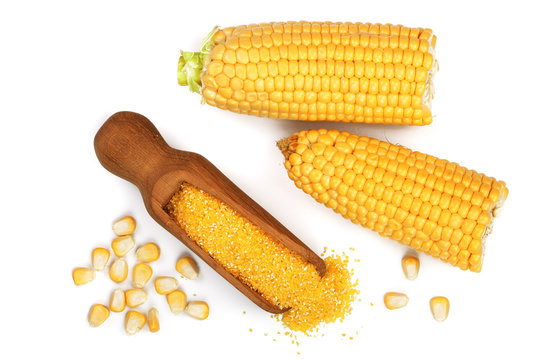 corn groats or cornmeal in wooden scoop and corncob isolated on white background. Top view. Flat lay