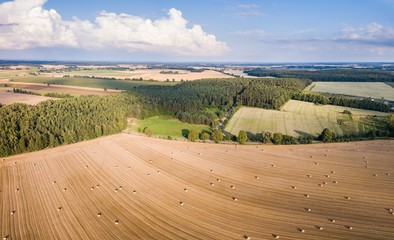 Aerial: stubble field with straw bales at late summer