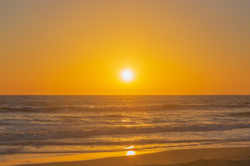 Sunset over ocean waves and beach