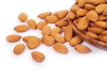 Almonds in wooden dish on white background.