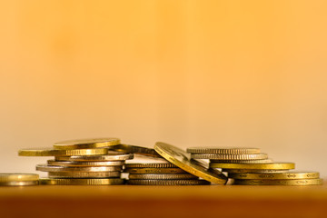 Coins on one another in a pile of on the table. Light background