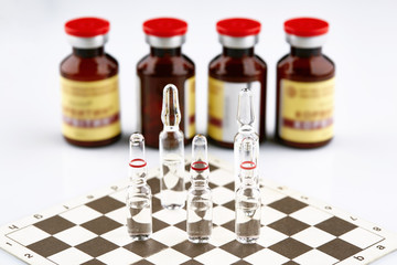 Ampoules on chess board, bottles with medicine