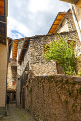 Fortified town Tende on Franco-Italian border in French Alps has alpine architecture with the medieval buildings grouped tightly together.