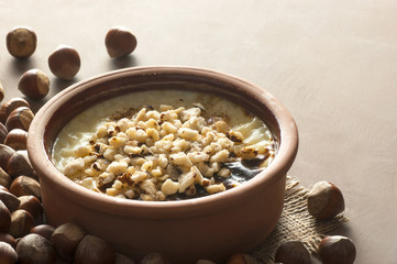 Baked rice pudding turkish milky dessert sutlac in earthenware casserole with hazelnuts