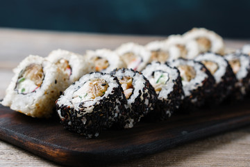 Tasty traditional food, Japanese culture. Sushi rolls with crab meat covered with white and black sesame seeds, close up