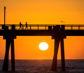 Women walking along fishing Pier