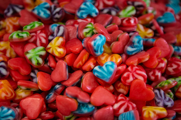 Jelly candies in form of heart. Red,colorful and multi-colored background of sweets. Colorful Confectionery ornaments. Cheerful Mix Of Multi-colored Candies. Children's Holiday Concept.