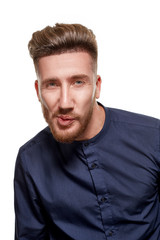 Obraz premium Portrait of a serious bearded man in a blue shirt, isolated over a white background.