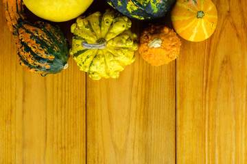 Colorful decorative pumpkins and gourds in autumn on wooden table.