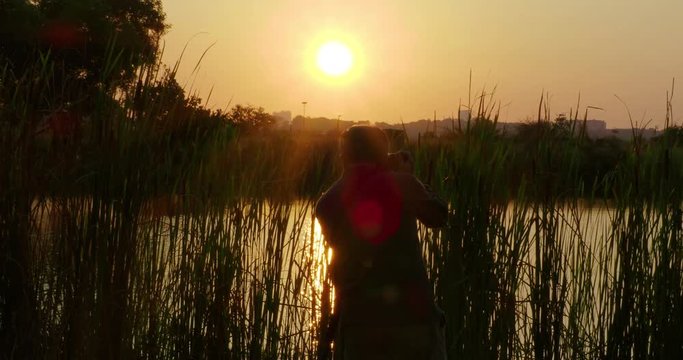 Photographer Taking Picture of Sunset at lake