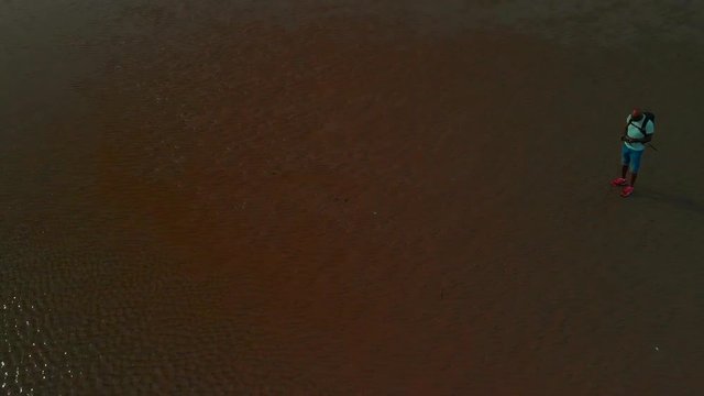 Beautiful views from drone of a long wide beach during low tide under a blue cloudy sky with some views of a family walking along.