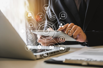 business man hand working with laptop computer, tablet and smart phone in office with digital marketing media  in virtual icon at  office in morning light 
