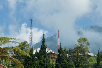 A tower of cellular communication on a hill of a mountain in clouds