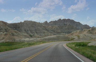 Naklejka premium Paved roads wind around the impressive land and rock formations at Badlands National Park in South Dakota.