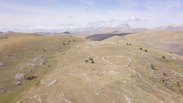 AERIAL: drone flying over the mountains near the Gran Sasso mountain, Abruzzo, Italy, in a sunny day.