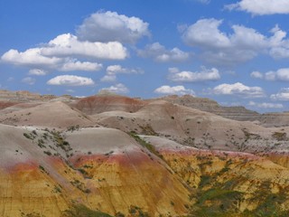 Naklejka premium Closeup of colorful rock formations with gorgeous clouds above at Badlands National Park in South Dakota, USA.