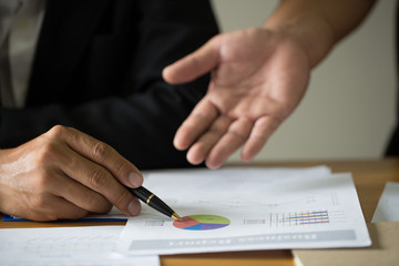 Business people discussing the charts and graphs showing the results of their successful teamwork