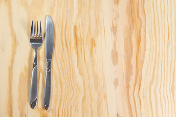 fork and knife on wooden table 