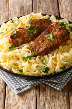 Cooker Chicken Lazone is seasoned breast fried in butter, pressure cooked until tender, served over pasta closeup. vertical