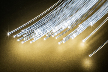 Bundle of optical fibers with lights in the ends. Yellow background.