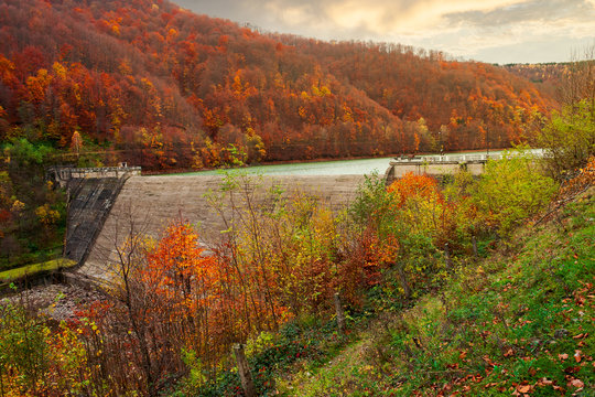 dam of water reservoir on the Tereblya river of Transcarpathia, Ukraine. beautiful autumn scenery with forest in red foliage