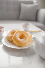 Classic donut. Morning breakfast with tea on table in living room at home.